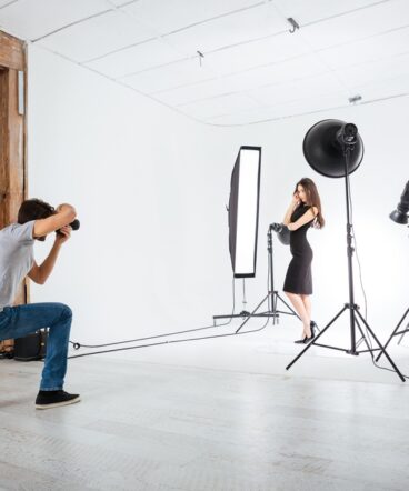 Photographer working with model in studio with equipments